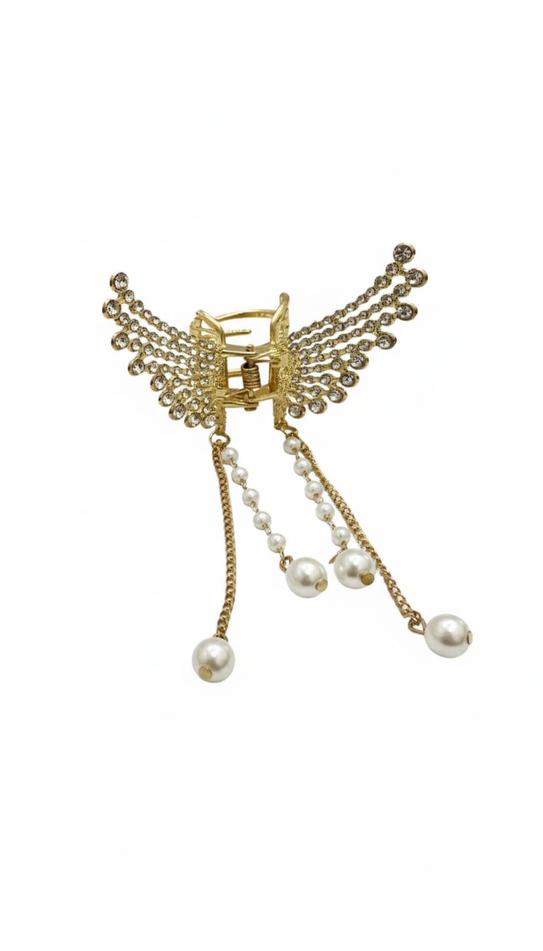 Decorative brooch with gold accents and pearl-like beads on a white background