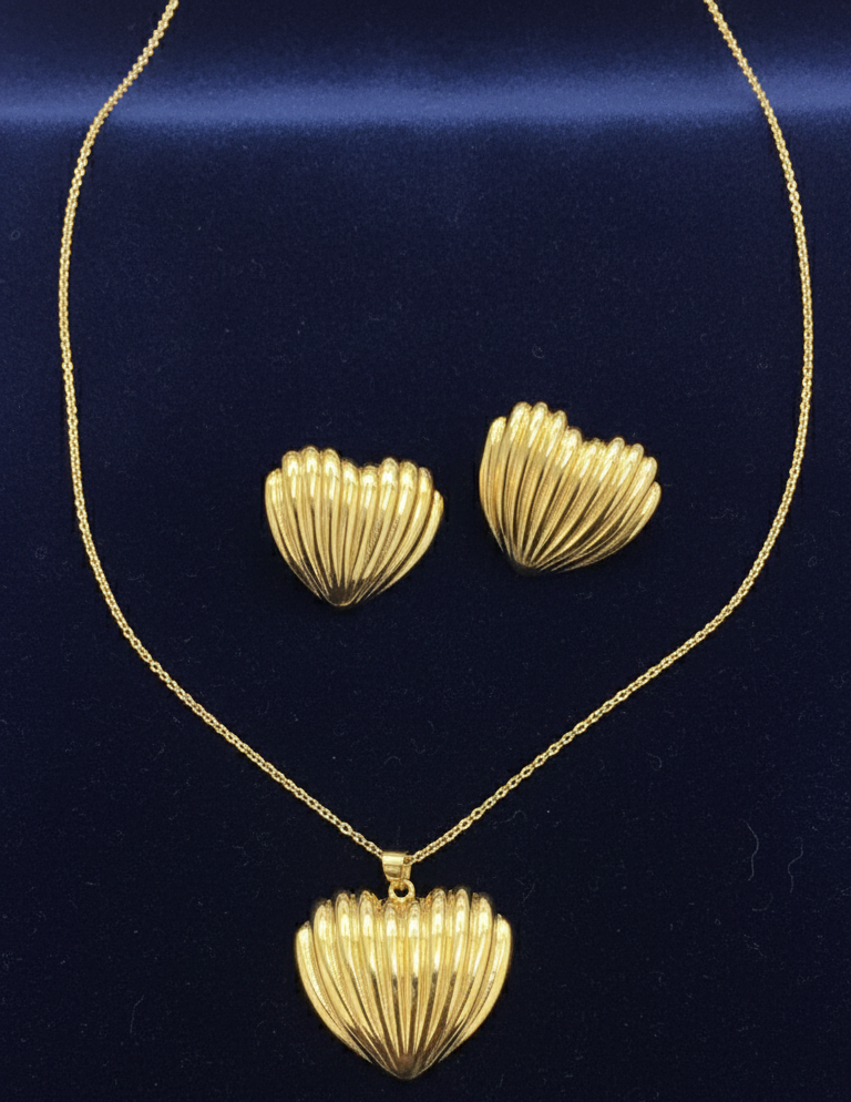 Gold heart-shaped necklace and earrings on a blue background