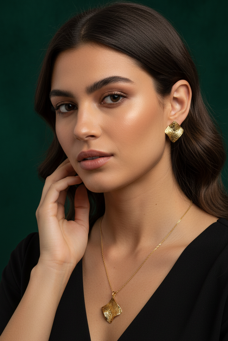 Woman wearing gold jewelry against a dark green background