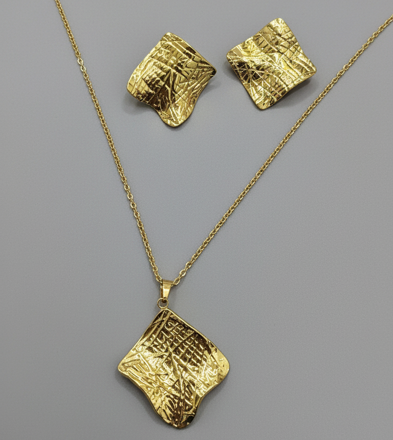 Gold necklace and earrings on a gray background