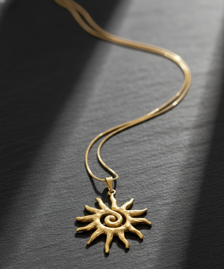 Gold sun-shaped pendant on a dark textured background