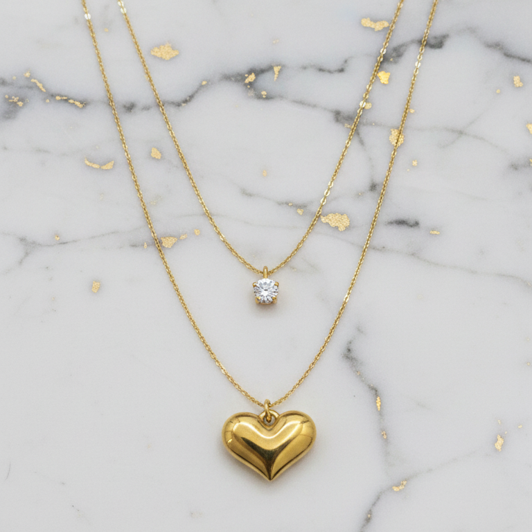 Gold heart-shaped pendant necklace on a marble background