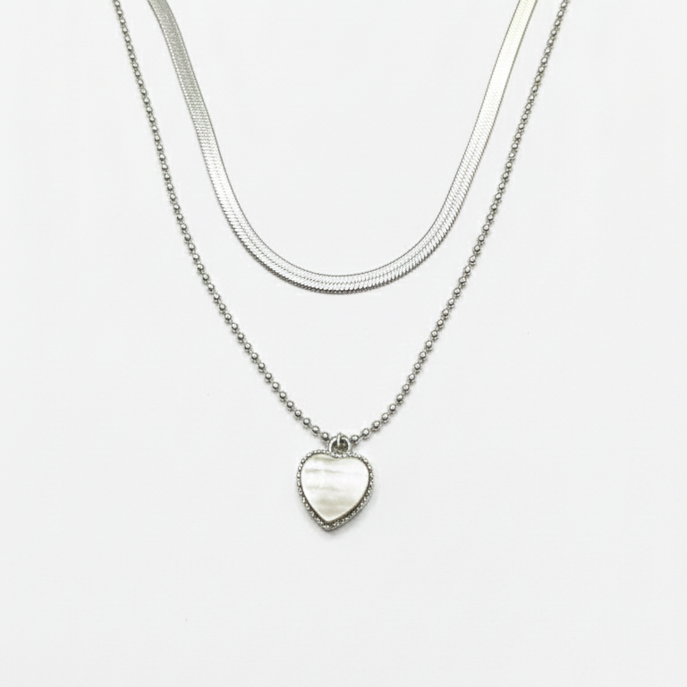 Silver necklace with a heart-shaped pendant on a white background
