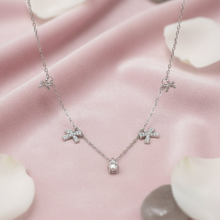 Necklace with butterfly pendants on a pink fabric background