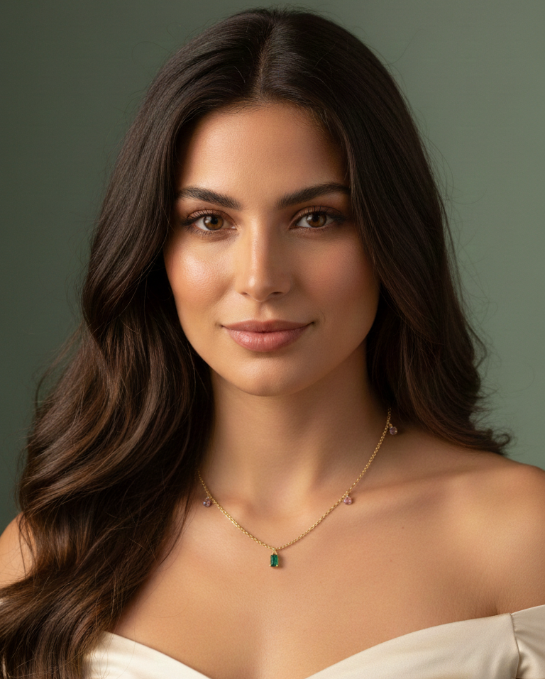Woman wearing a necklace with a green pendant against a neutral background